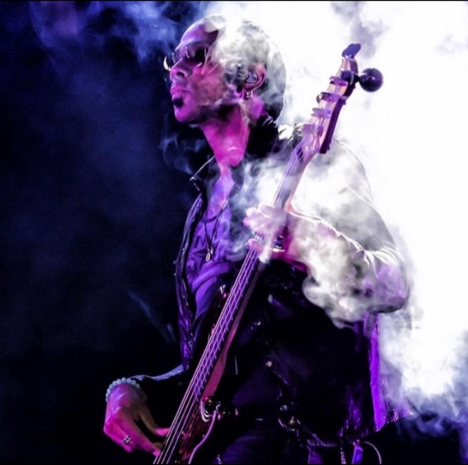 Al Berry playing bass through violet theatrical smoke